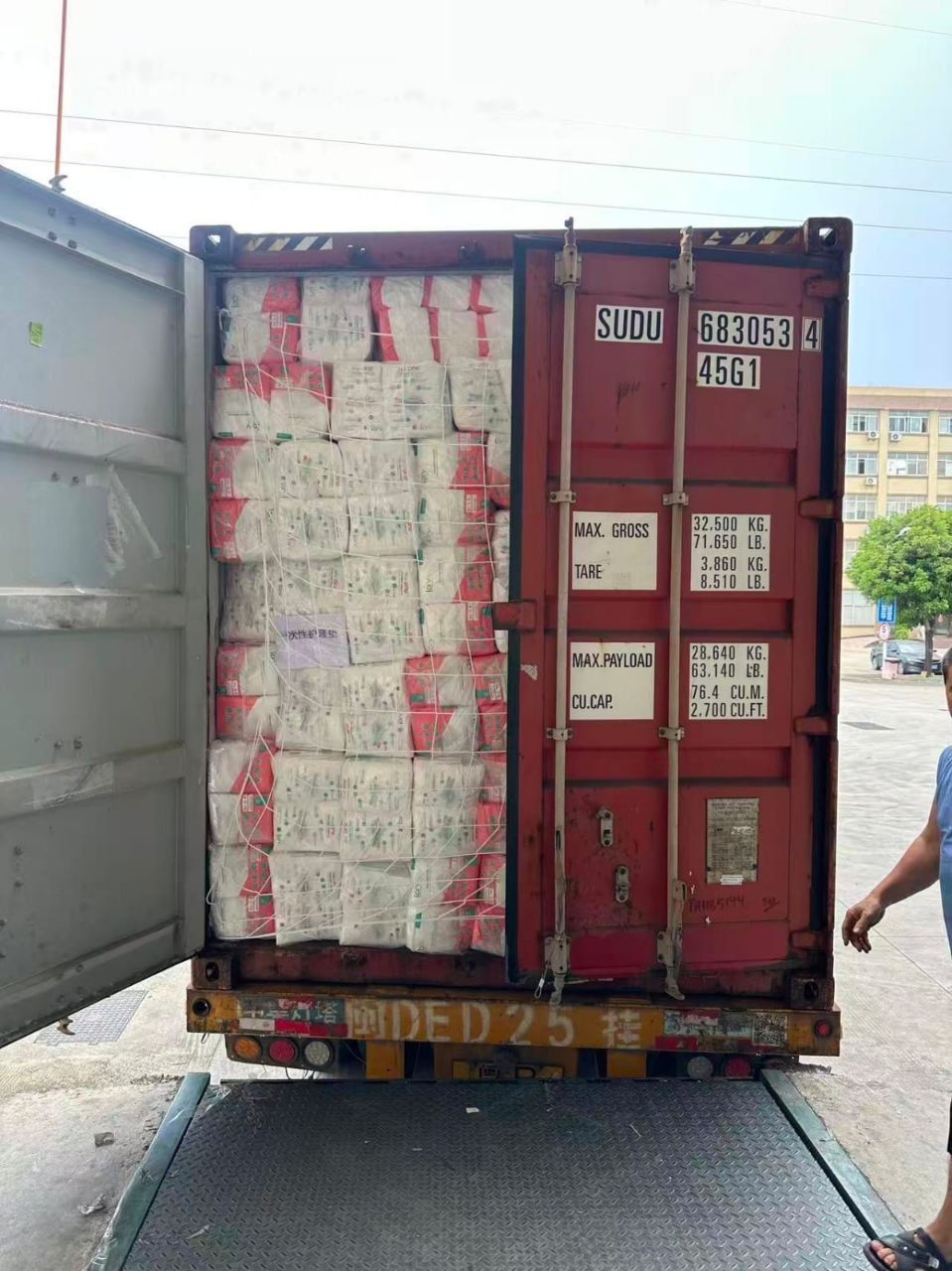 Открытый морской контейнер, загруженный тюками до дверей